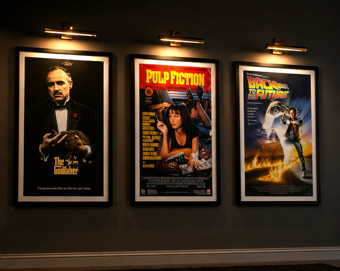 Framed movie posters on a home theater wall with dark paint, warm lighting, and clean spacing